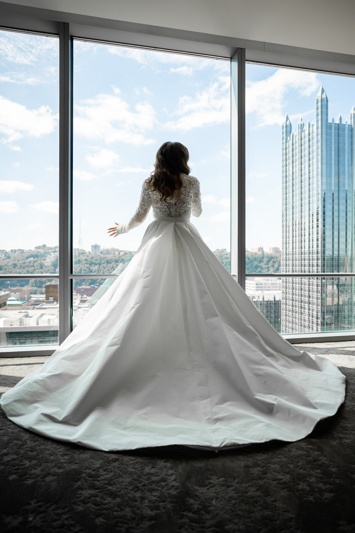 bride posing in window of fairmont hotel wedding suite