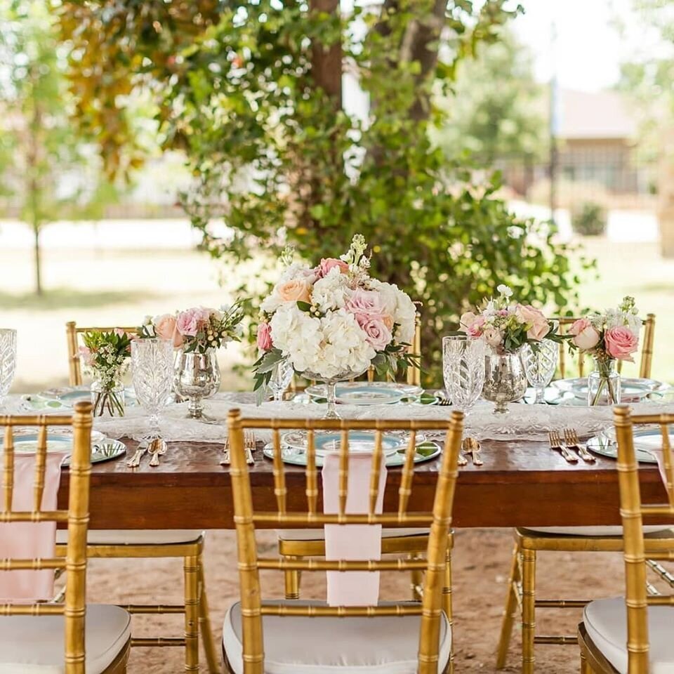 Chiavari Chairs line a top table decorated with fresh flowers and candles
