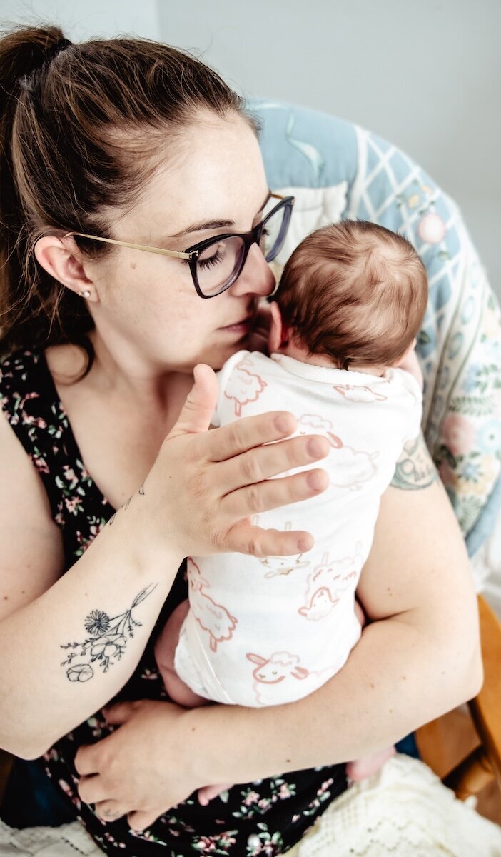 A new mama kisses her 2 day old baby