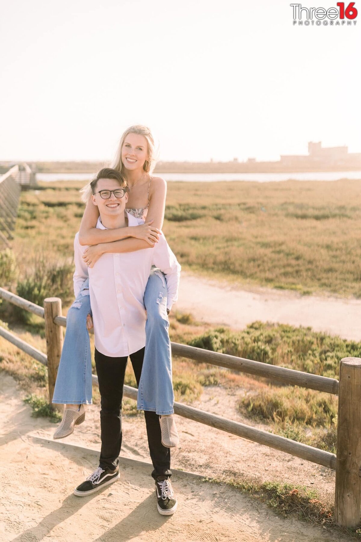 Groom to be carries his Bride on his back during photo session
