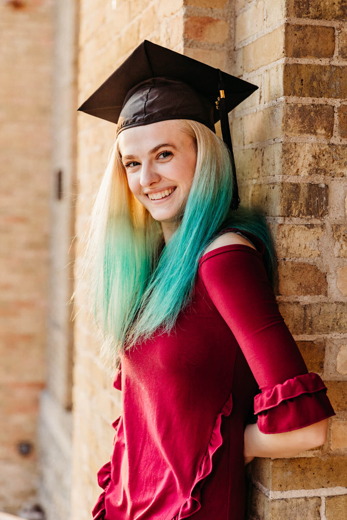 High school graduate posing with graduation cap on
