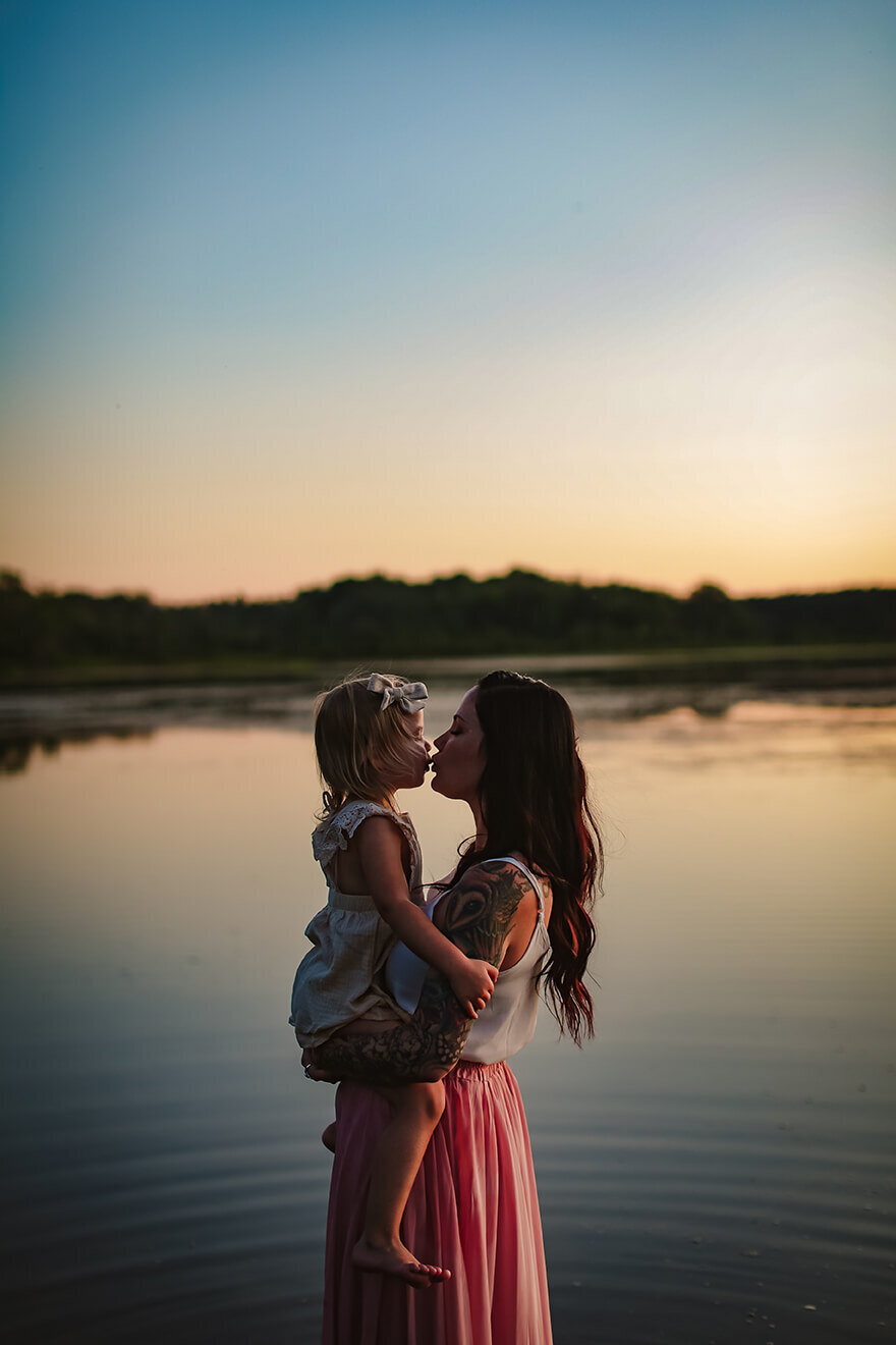 mother and daughter kissing in water