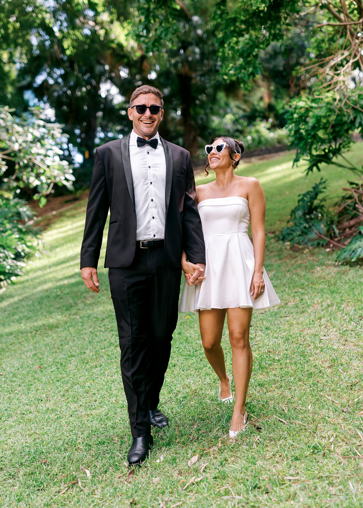 Stylish couple walking hand-in-hand in King Edward Park after their Brisbane registry wedding — fun and modern photography with personality.
