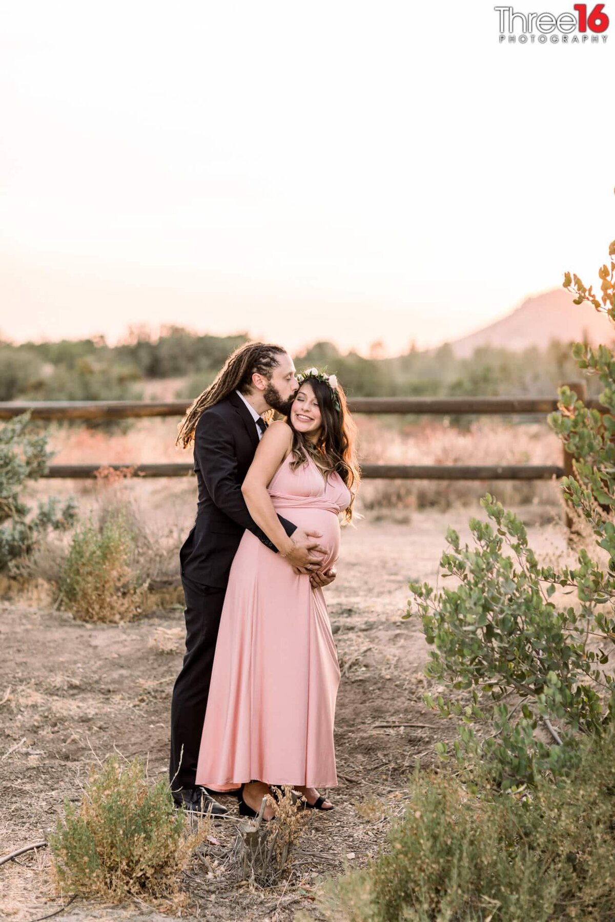 Dad to be kisses his Wife's cheek during maternity photo session