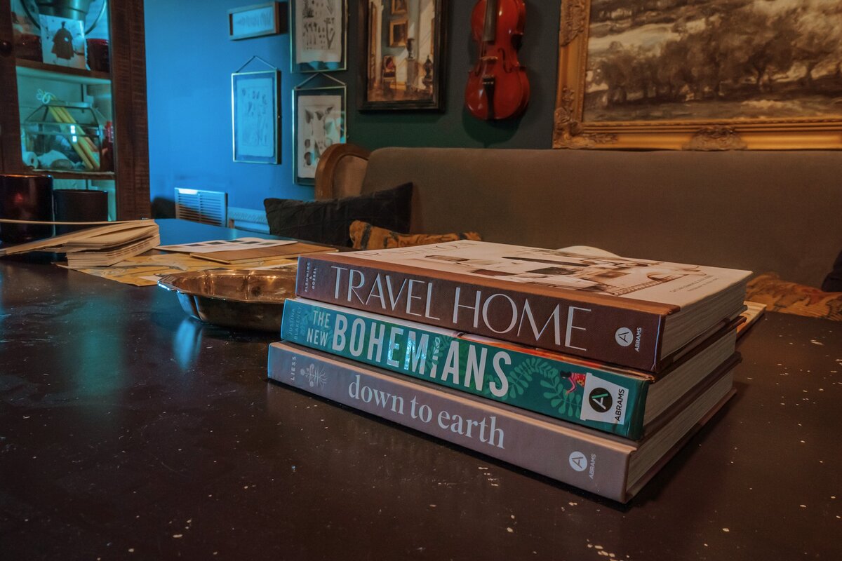 Steel wrapped table top with interior design books and a sofa bench with a gallery wall