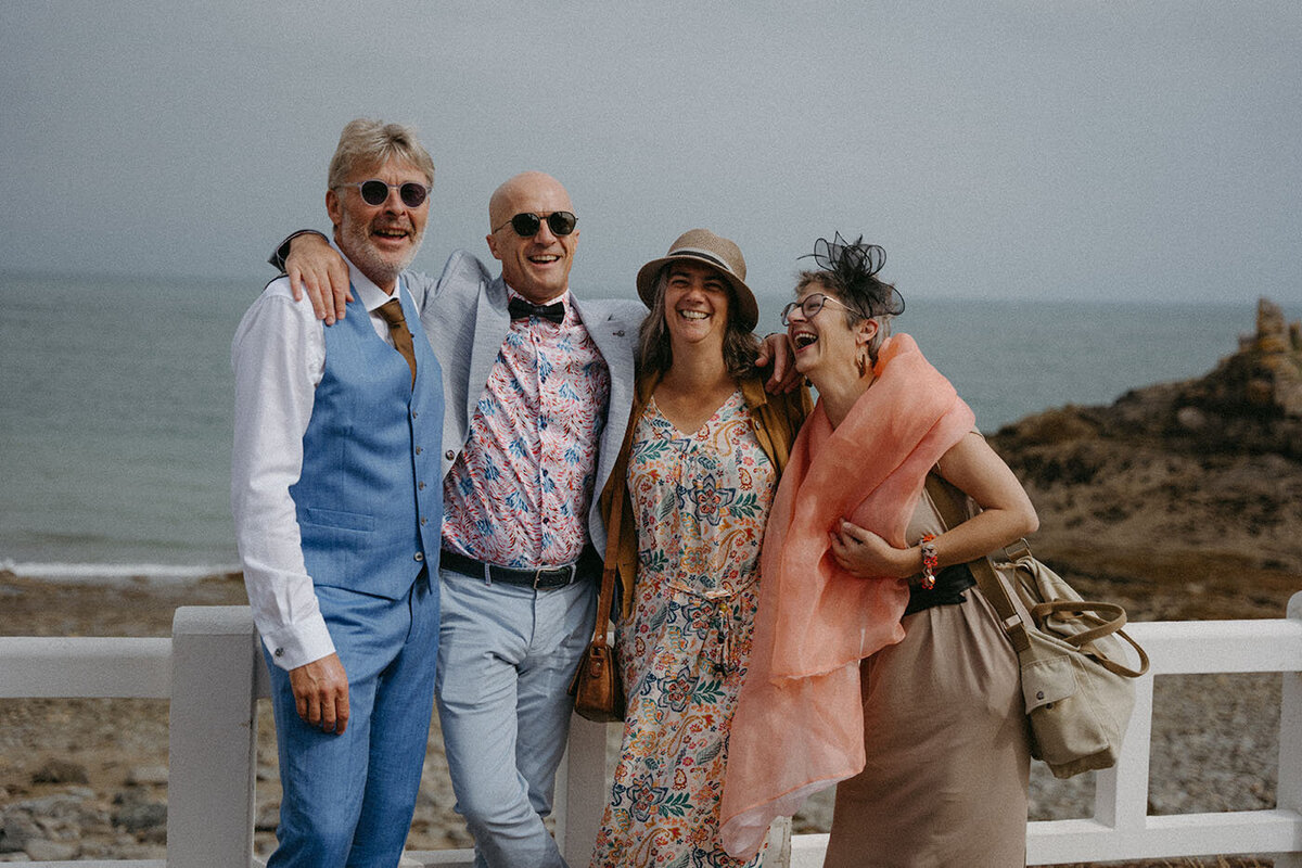 Patrick et ses invités rient face à la mer. Un mariage vintage à Saint-Quay-Portrieux, Bretagne, par Kamescop, photographe et vidéaste.