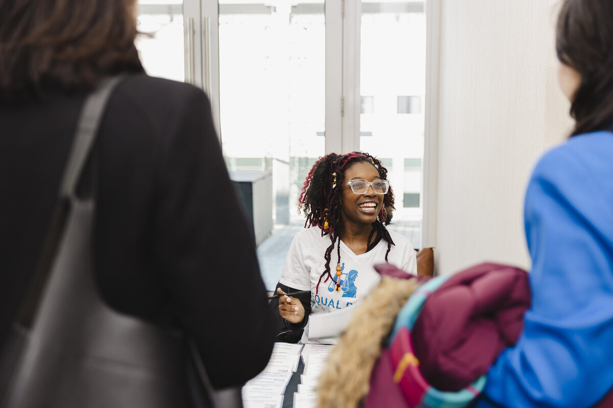 A person walks in to an event with a smile on their face.