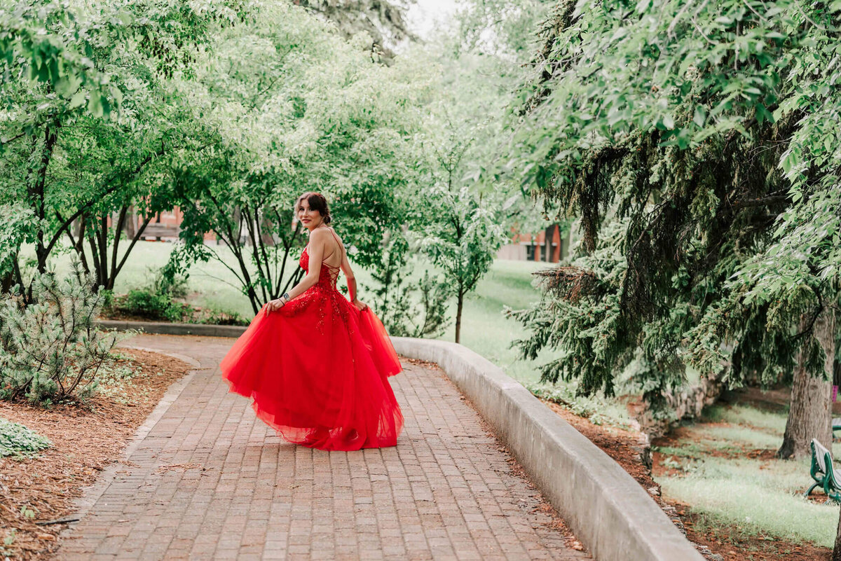 Spinning on a path holding her  dress. 