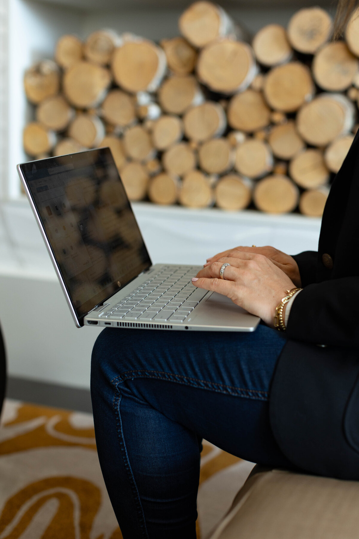 Hands on keyboard with stacked wood behind them