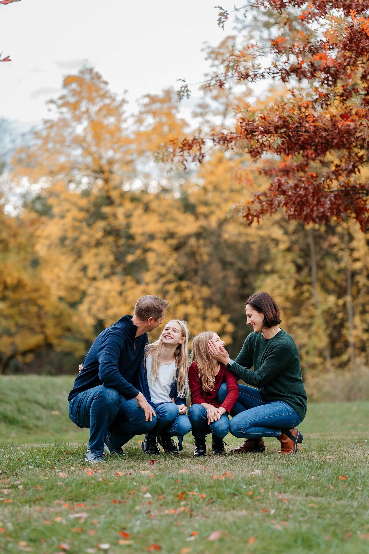Emotive family moment with everyone squatting down and looking at each other, sharing a loving and joyful interaction.