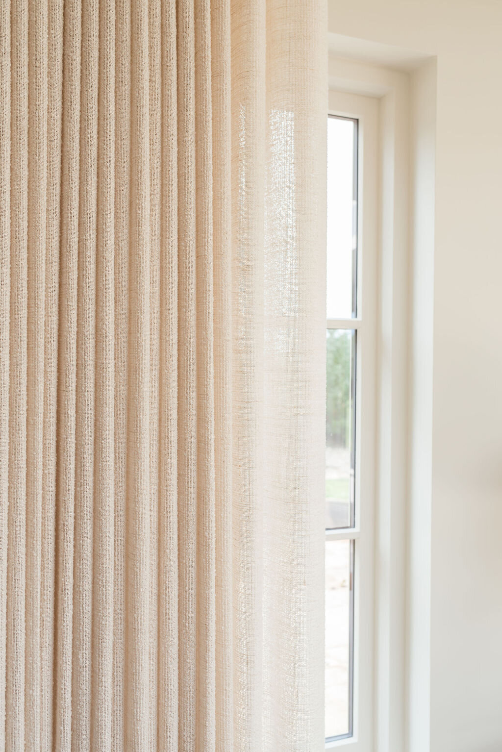 A close-up look at the thin neutral drapes in the cozy living room.