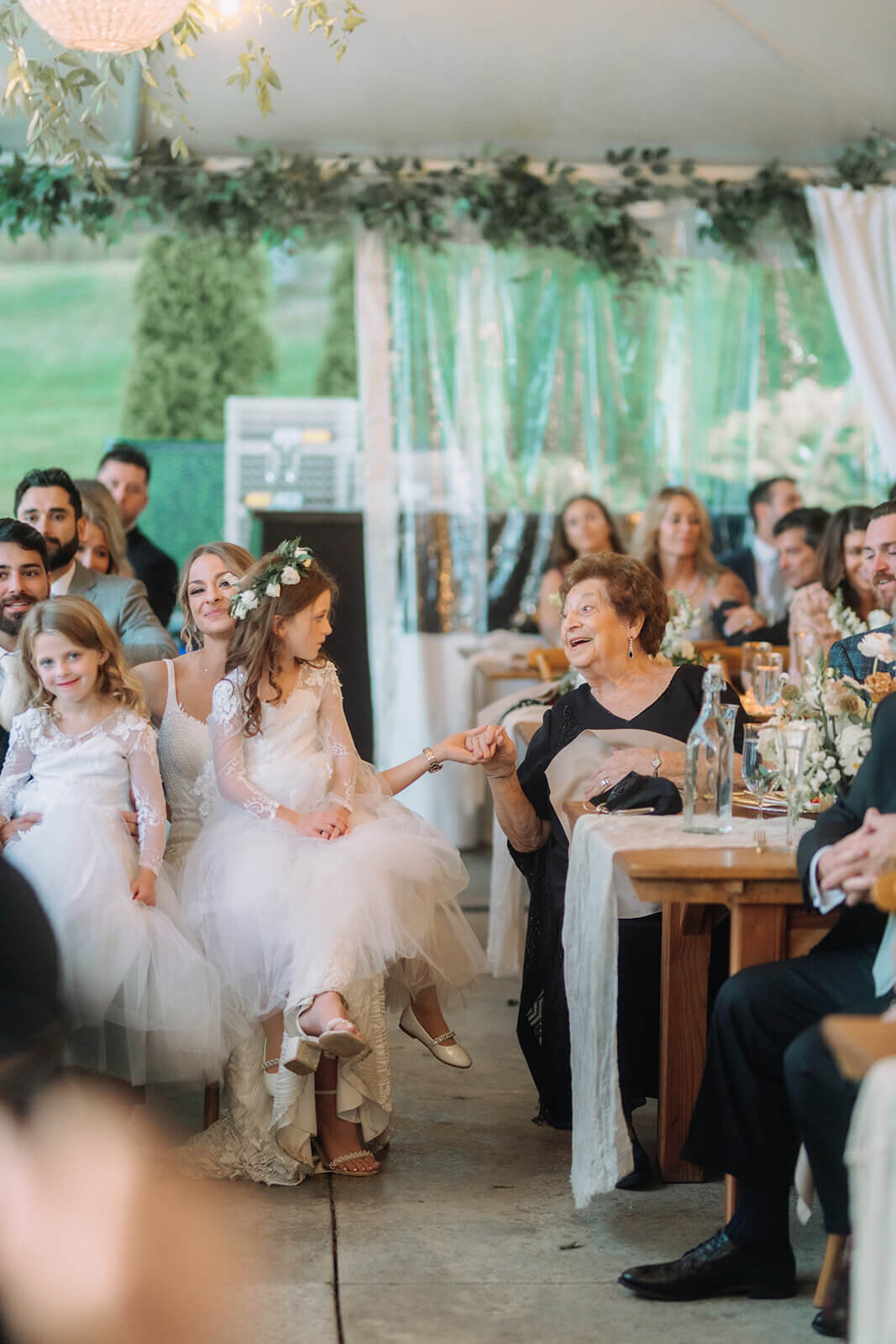 Flower girls with wedding guests at wedding reception