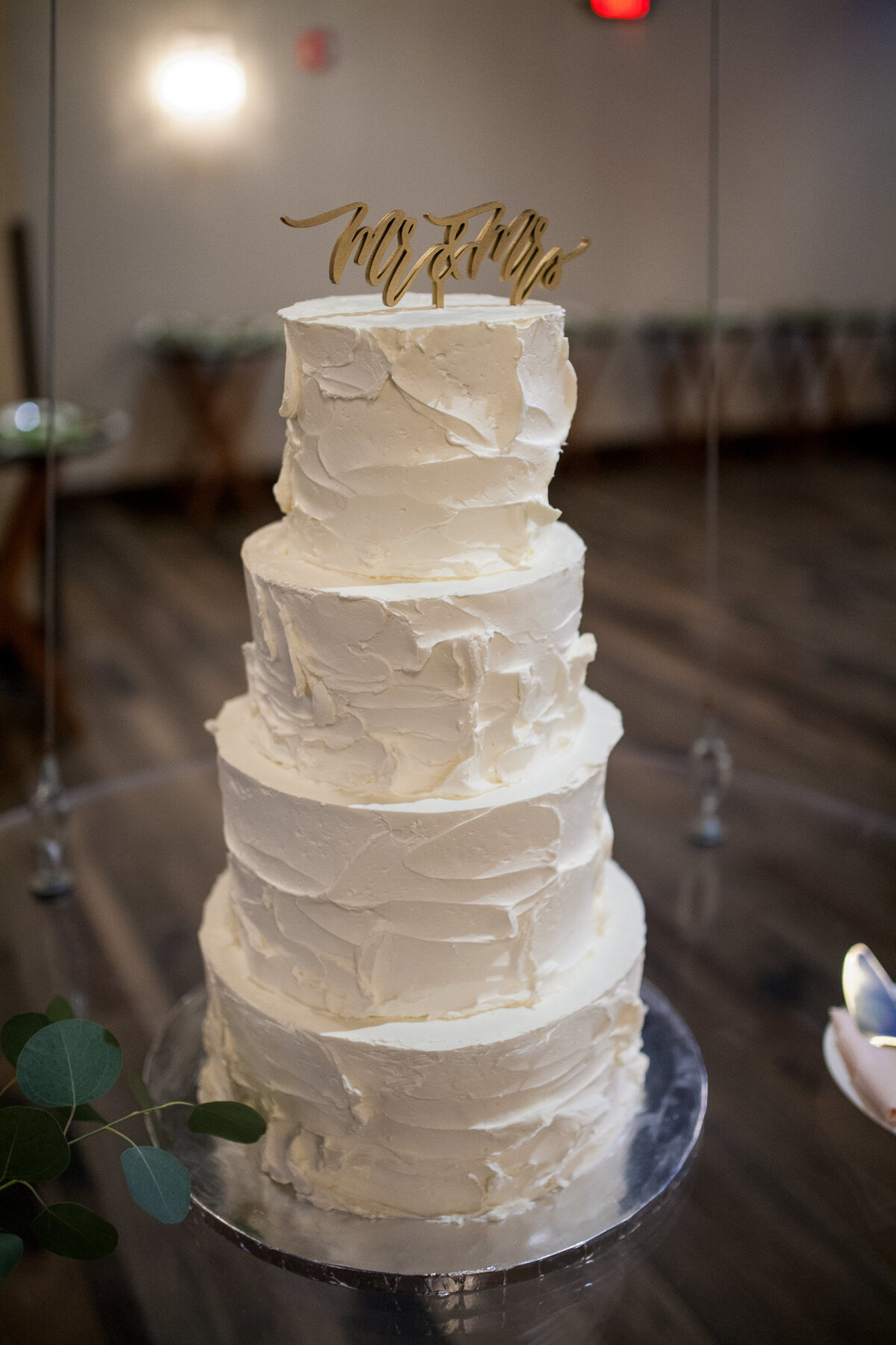 Four tier cake with “Mr & Mrs” wooden cake topper, at the Caramel Room in St. Louis.