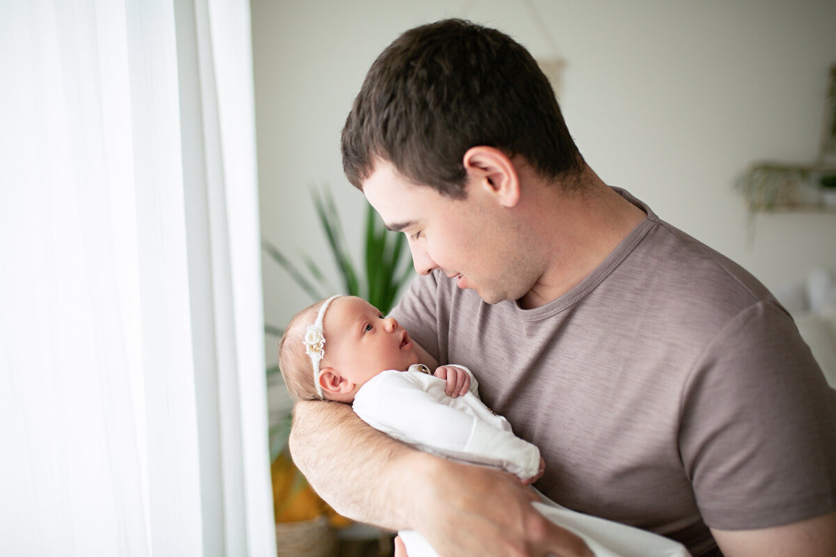 father and newborn daughter making eye contact