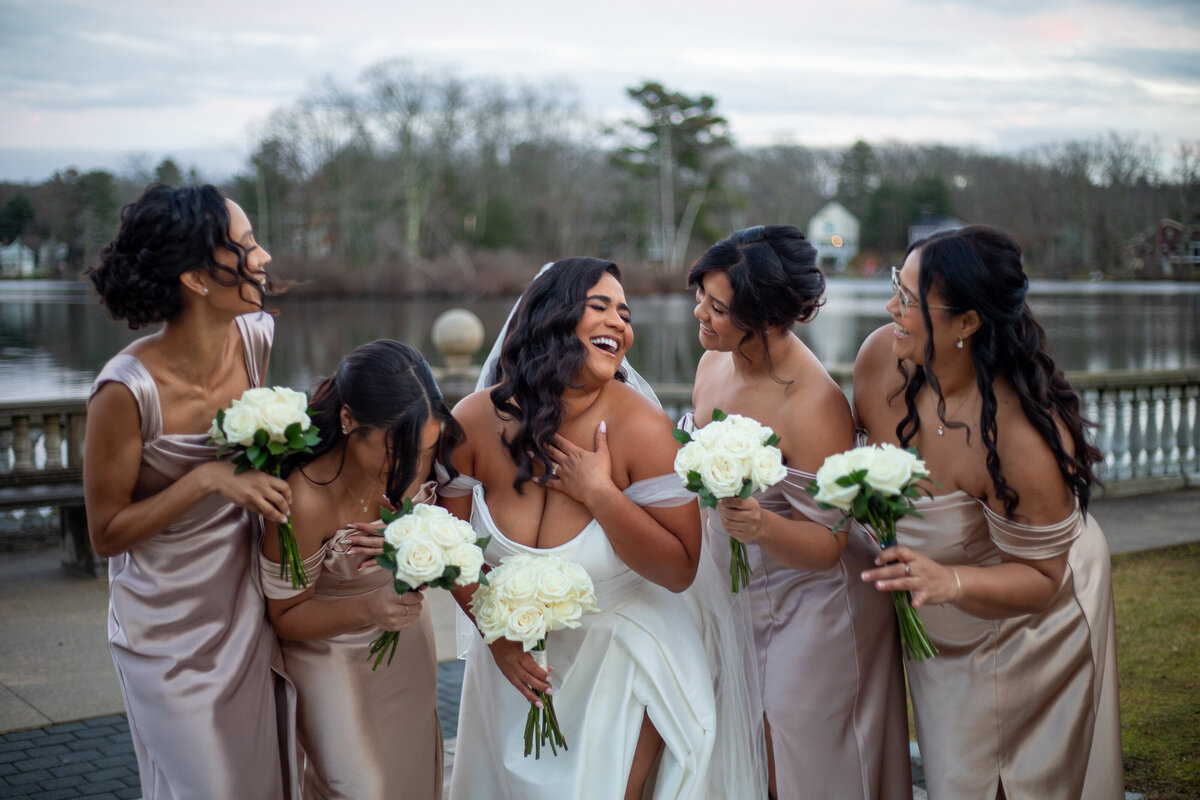 Bride laughing with her bridesmaids by her side