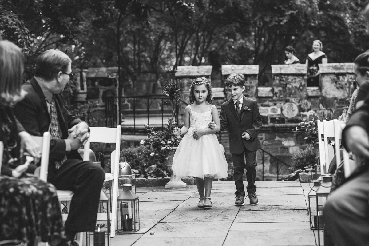 Two kids walking down the aisle at a wedding 