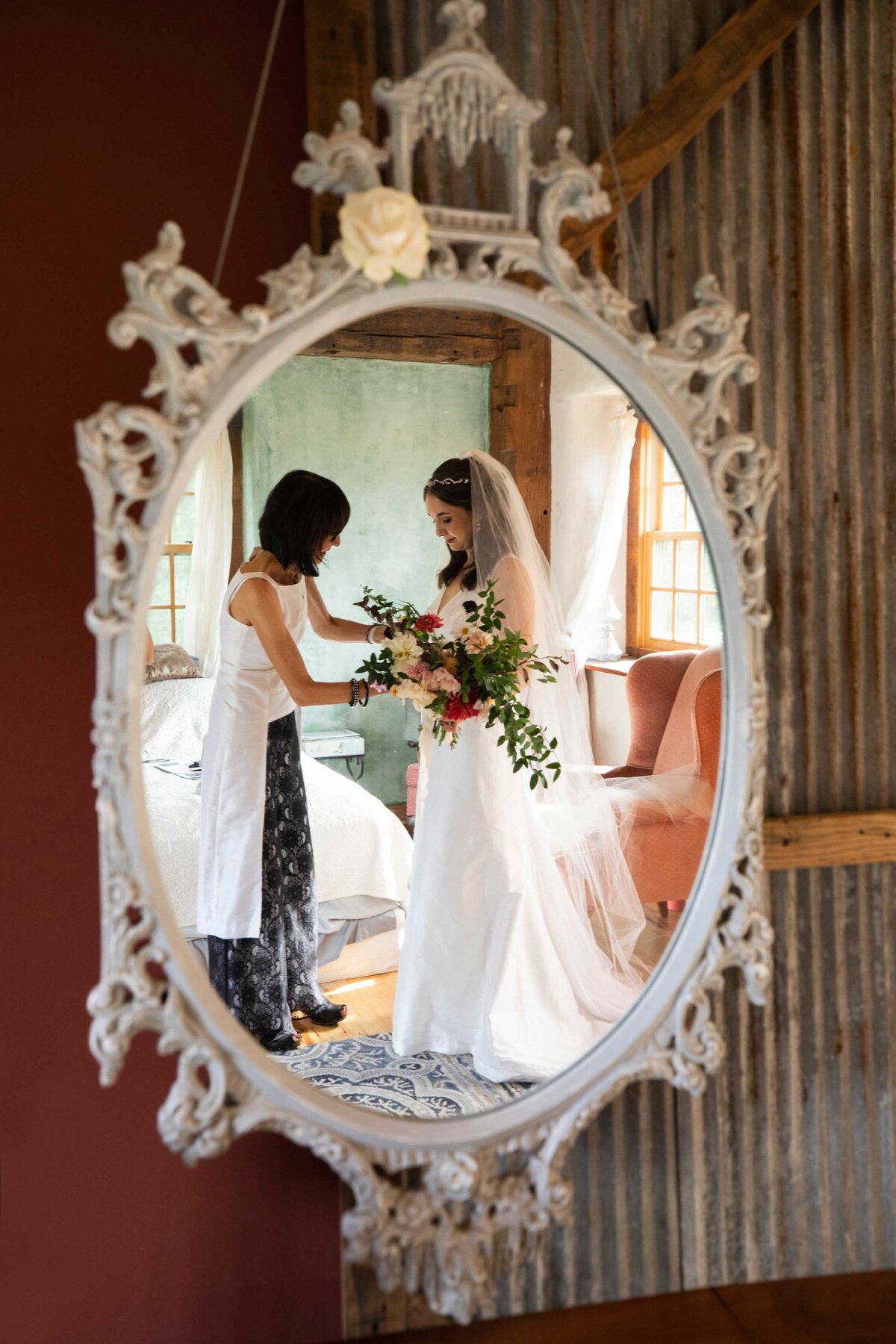 Mirror reflection picture of bride getting ready with mother of bride, holding her bridal bouquet. Zigbone Farm Retreat, Maryland