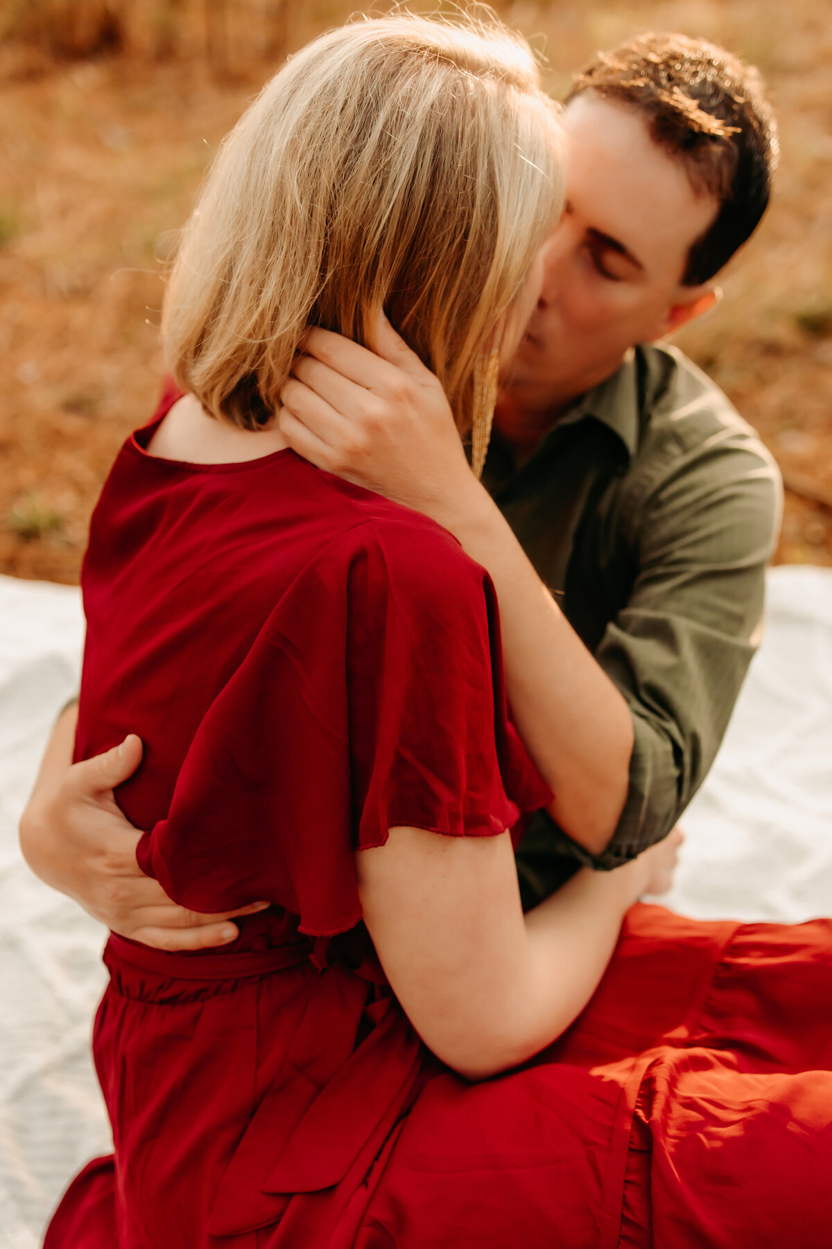 Spring TX couples photo of wife sitting on husband’s lap, kissing in intimate pose