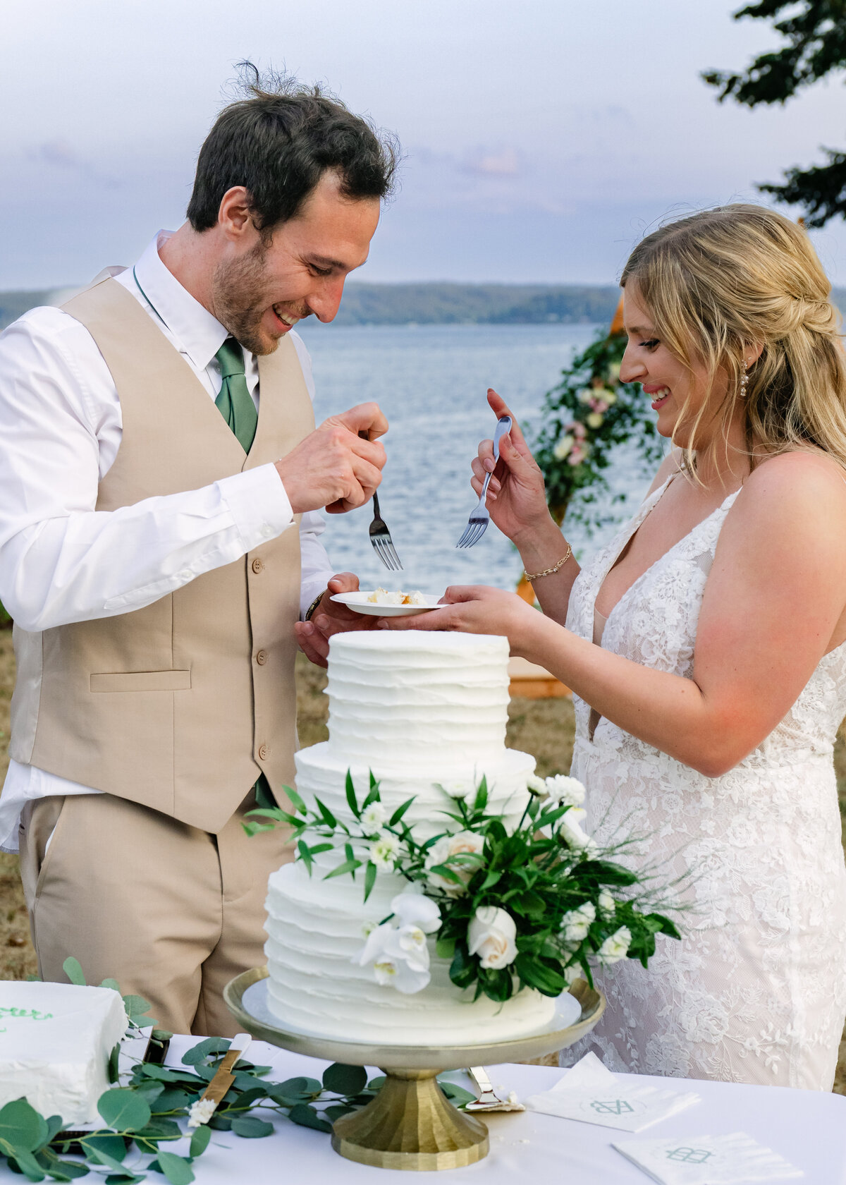 bride and groom cake cutting by ocean