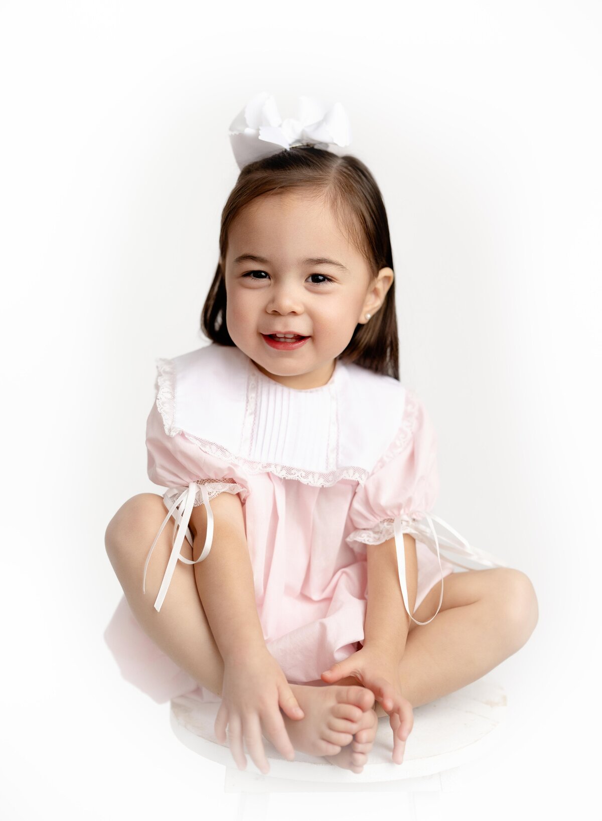 Girl sitting in heirloom outfit. Photo taken at Atlanta Children's Photography studio.