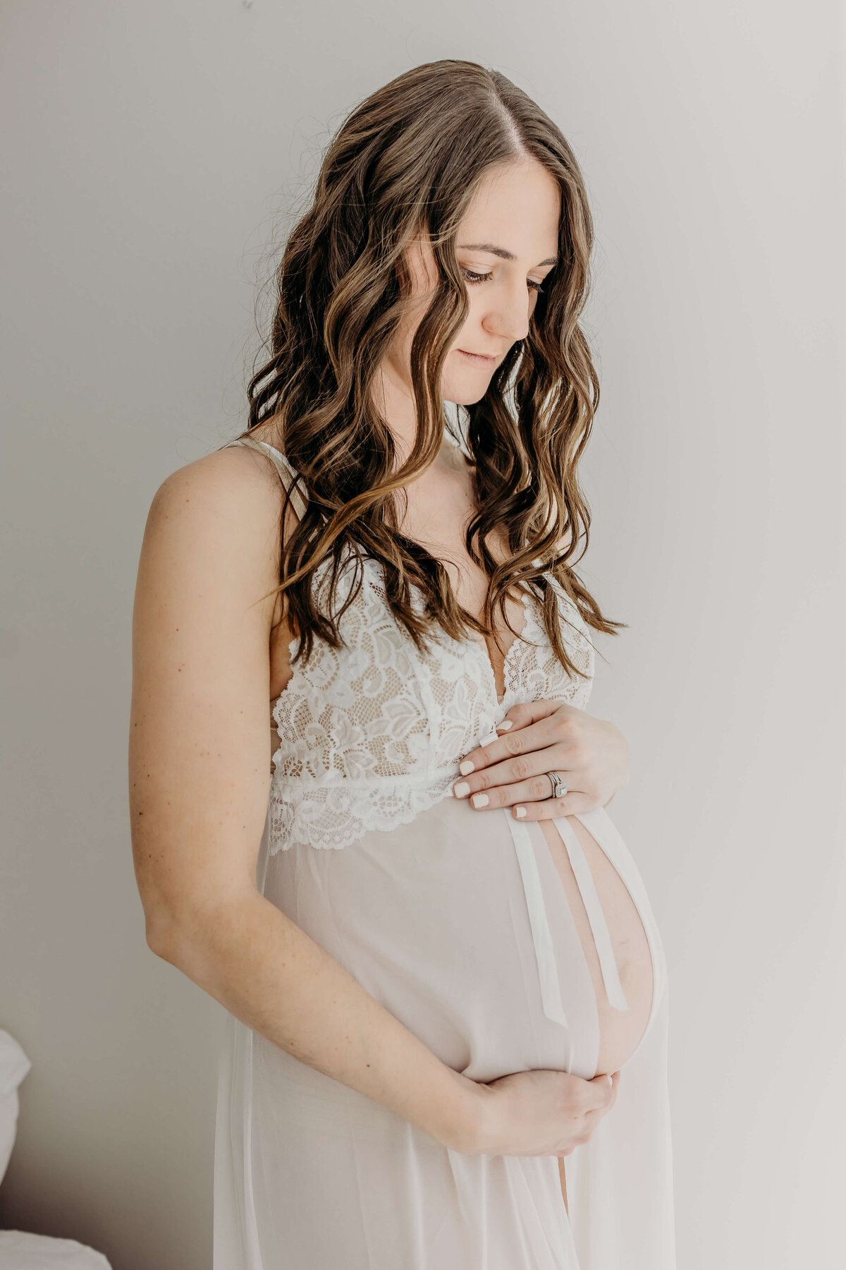 Pregnant mom holding belly in white robe