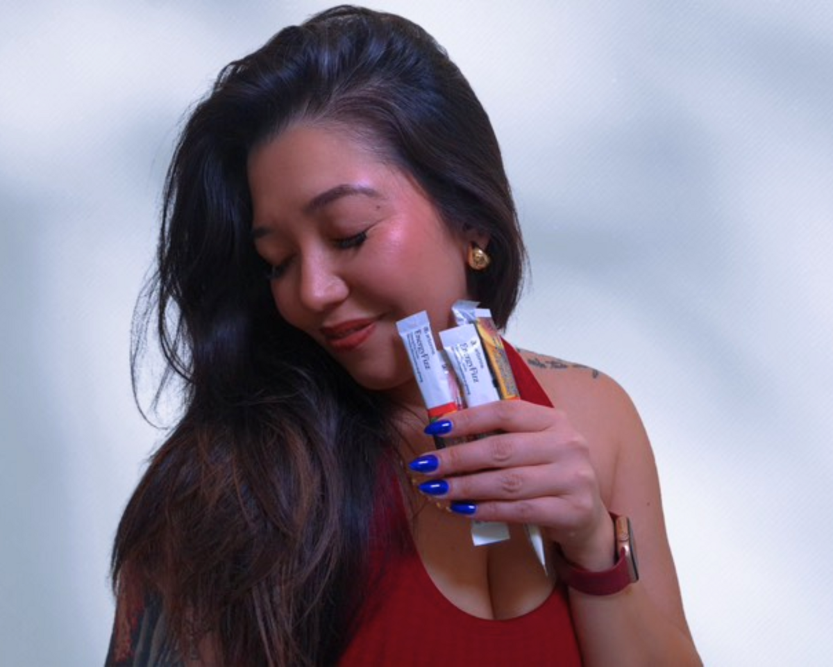 Jenni smiling while holding Arbonne wellness products, representing her authentic partnership and alignment with clean living and heart-led entrepreneurship