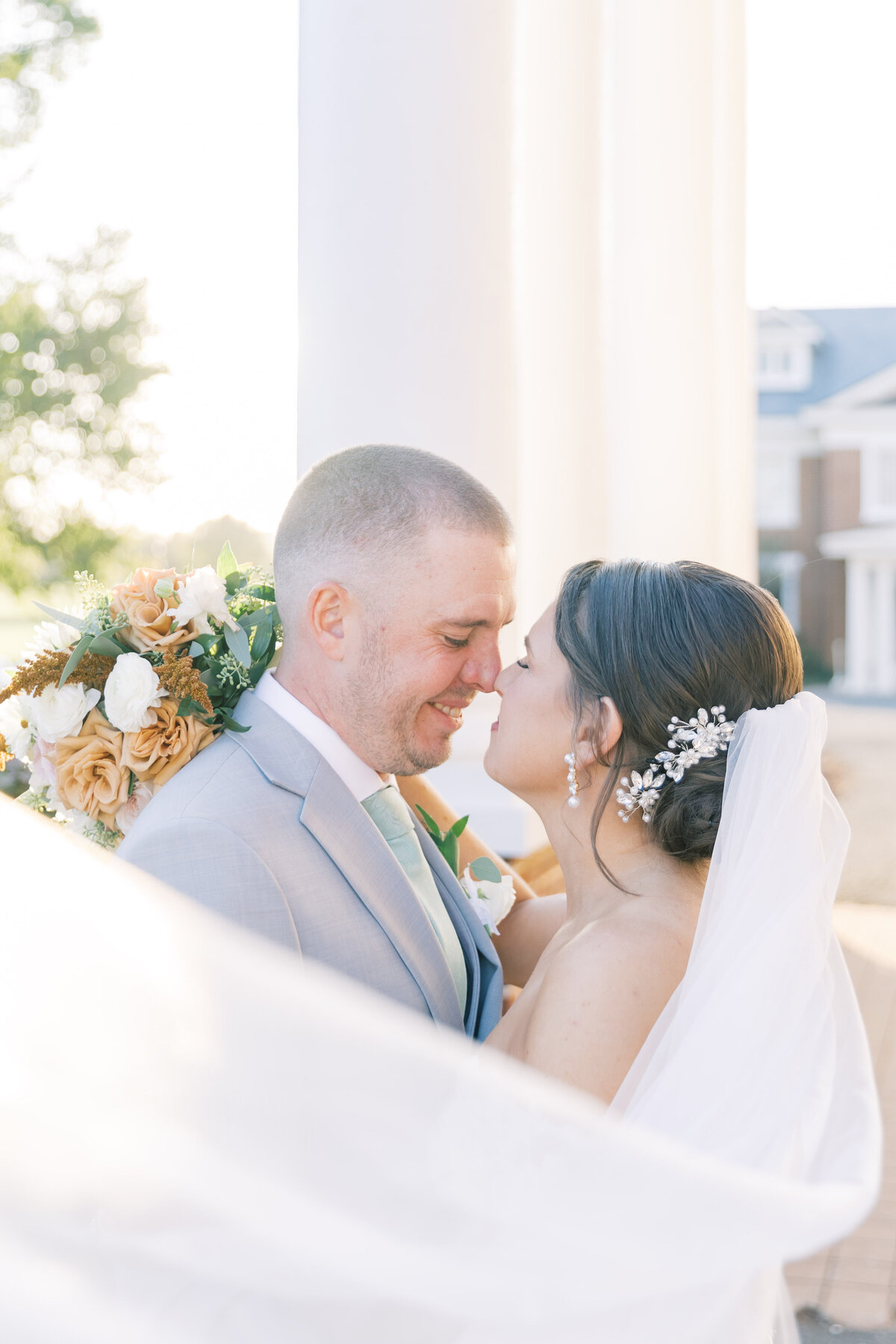 Wedding couple with veil flowing at Raspberry Plains Manor, capturing a romantic moment in Virginia.