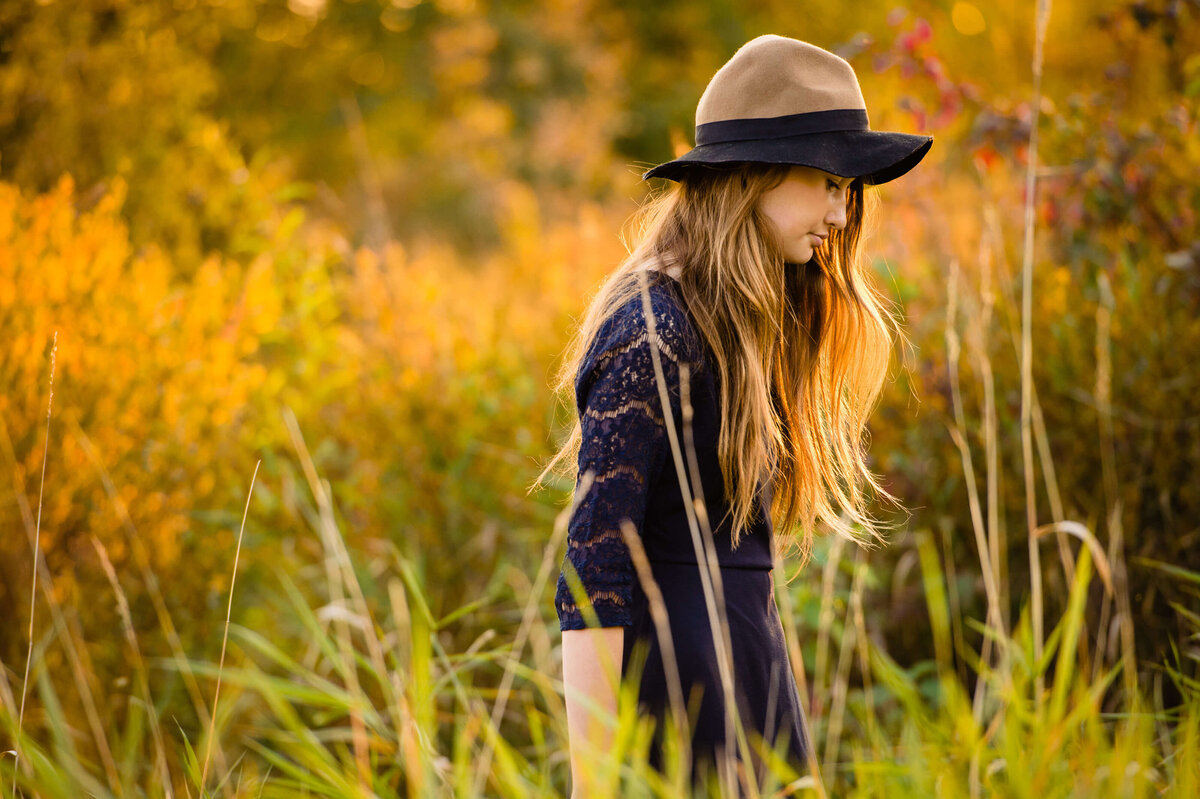 a teenager in long grass at sunset taken by Ottawa Family Photographer JEMMAN Photography