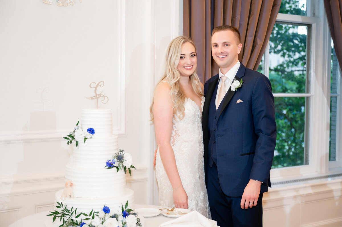 couple posing with their wedding cake during their reception