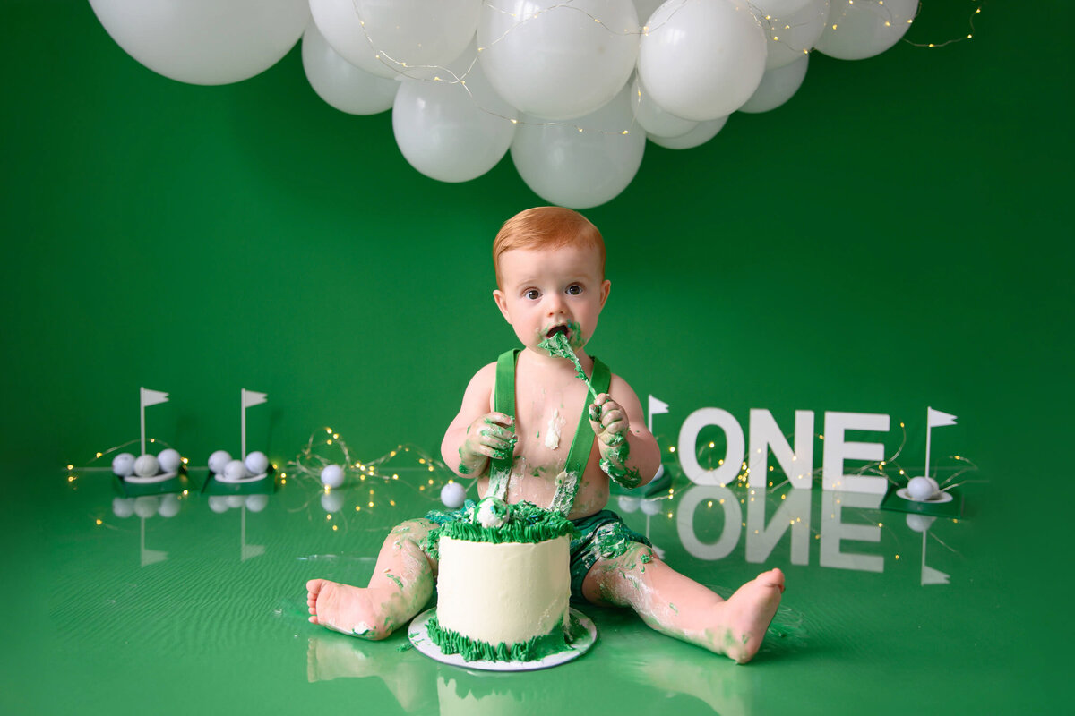 Red-haired baby boy for his first birthday cake smash photographer Burlington session hole in one them.