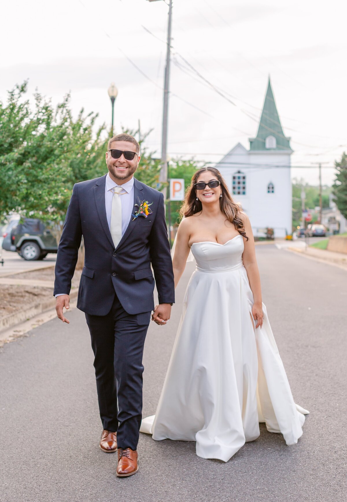 Bride and groom walking in the street by The Refinery at 120 in Culpeper, Virginia. Captured by Bethany Aubre Photography.