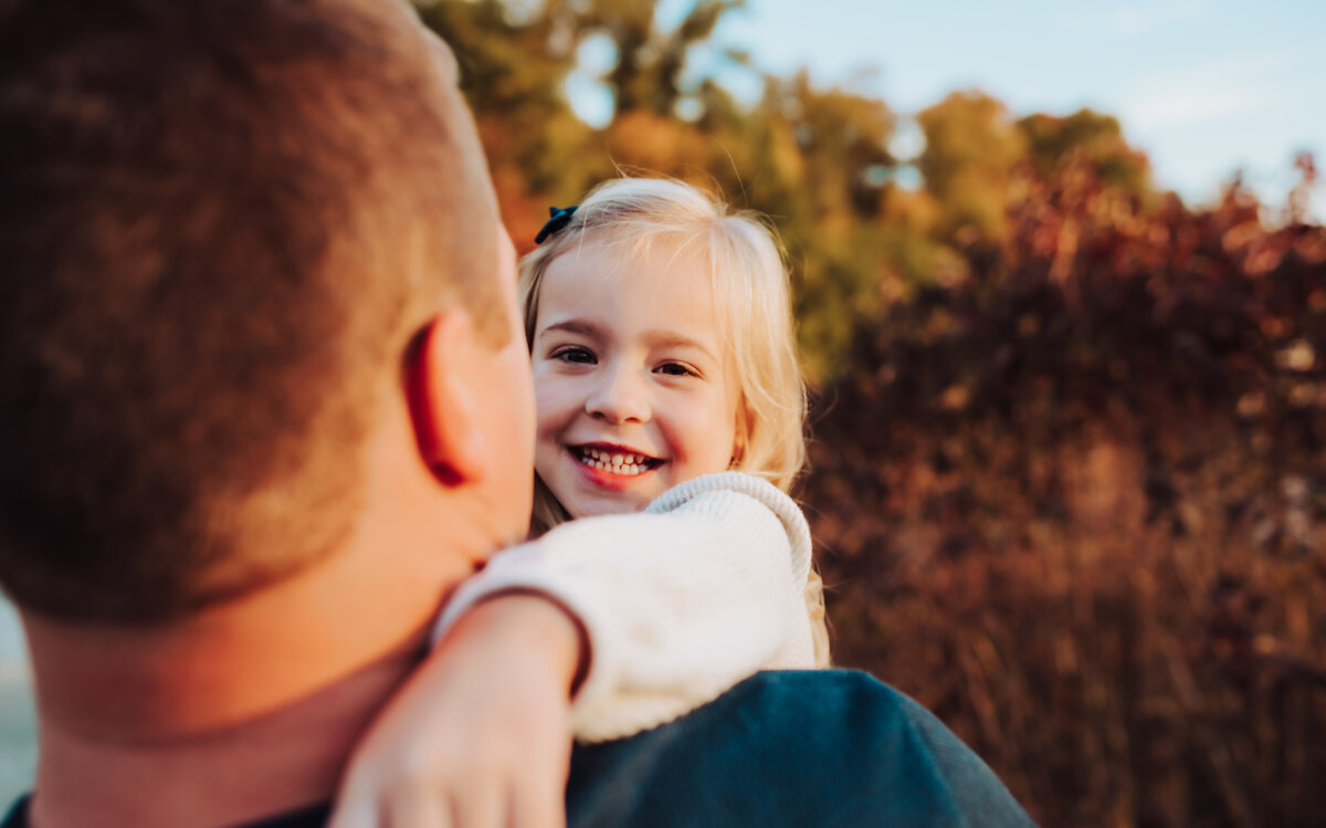 dad holding daughter , sunset in Toledo fields