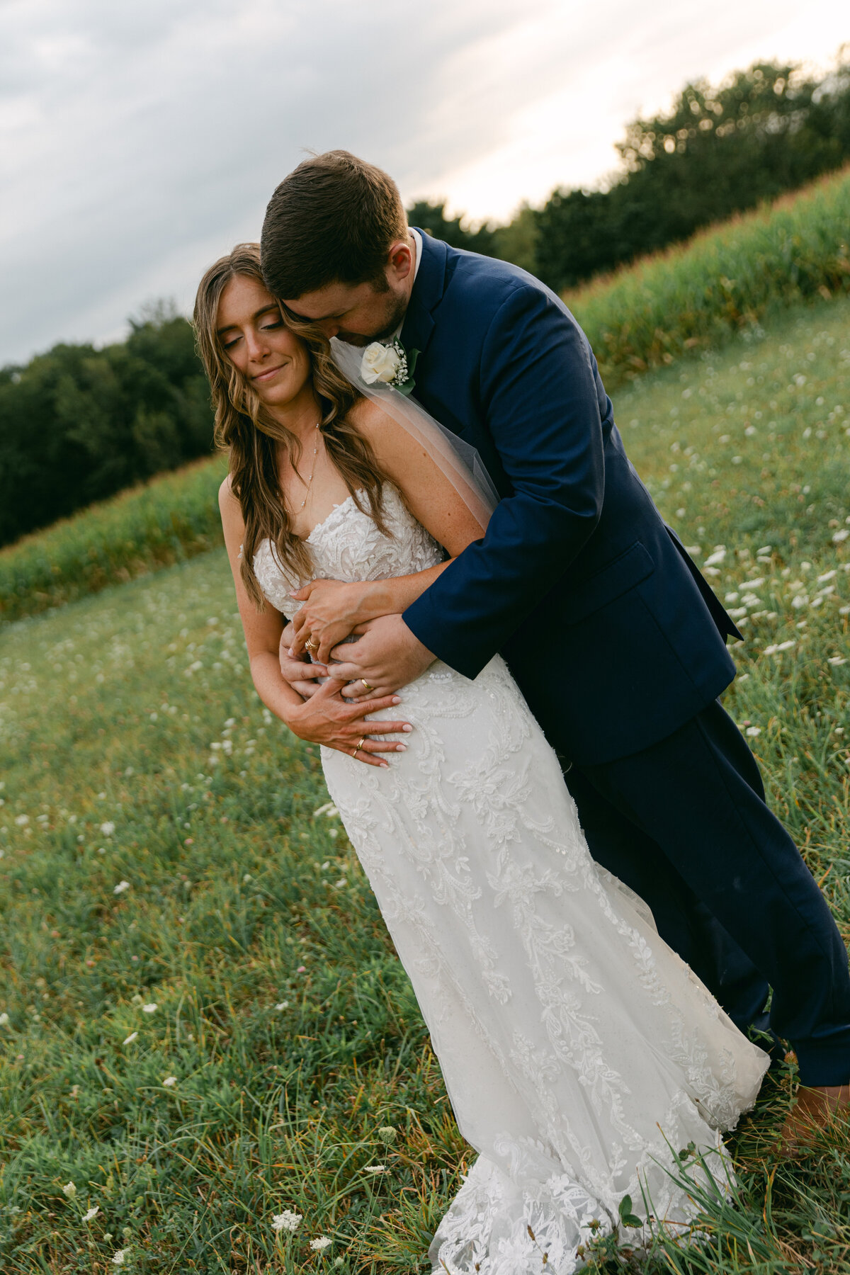 bride-groom-embrace-golden-hour-meadow
