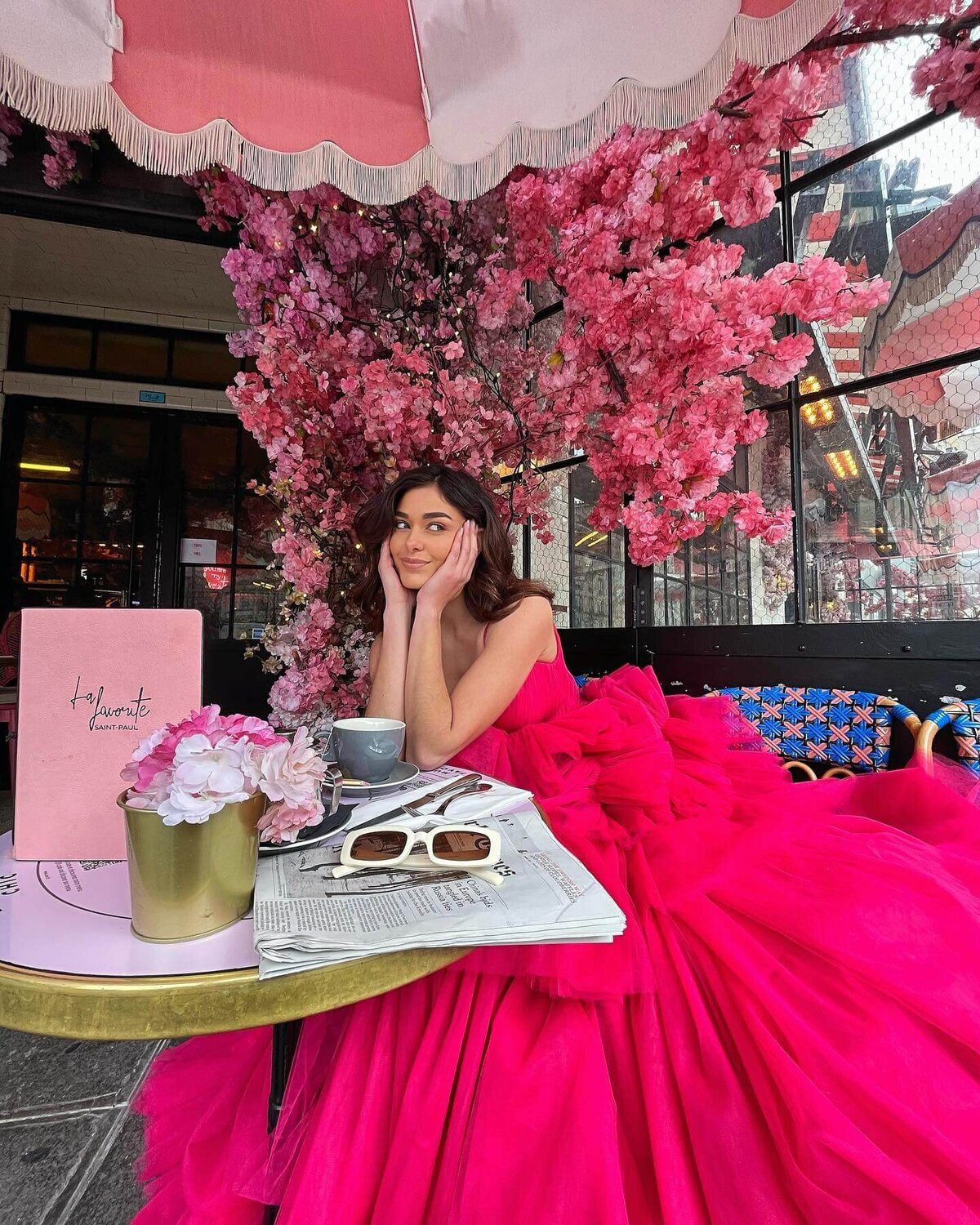 girl sitting in a cafe in paris with a pink princess gown