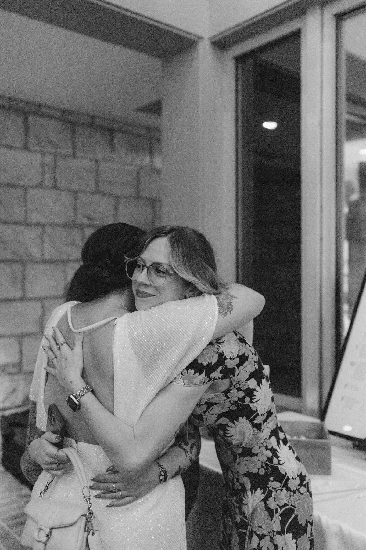 Bride hugging woman at Umlauf Sculpture Garden, Austin
