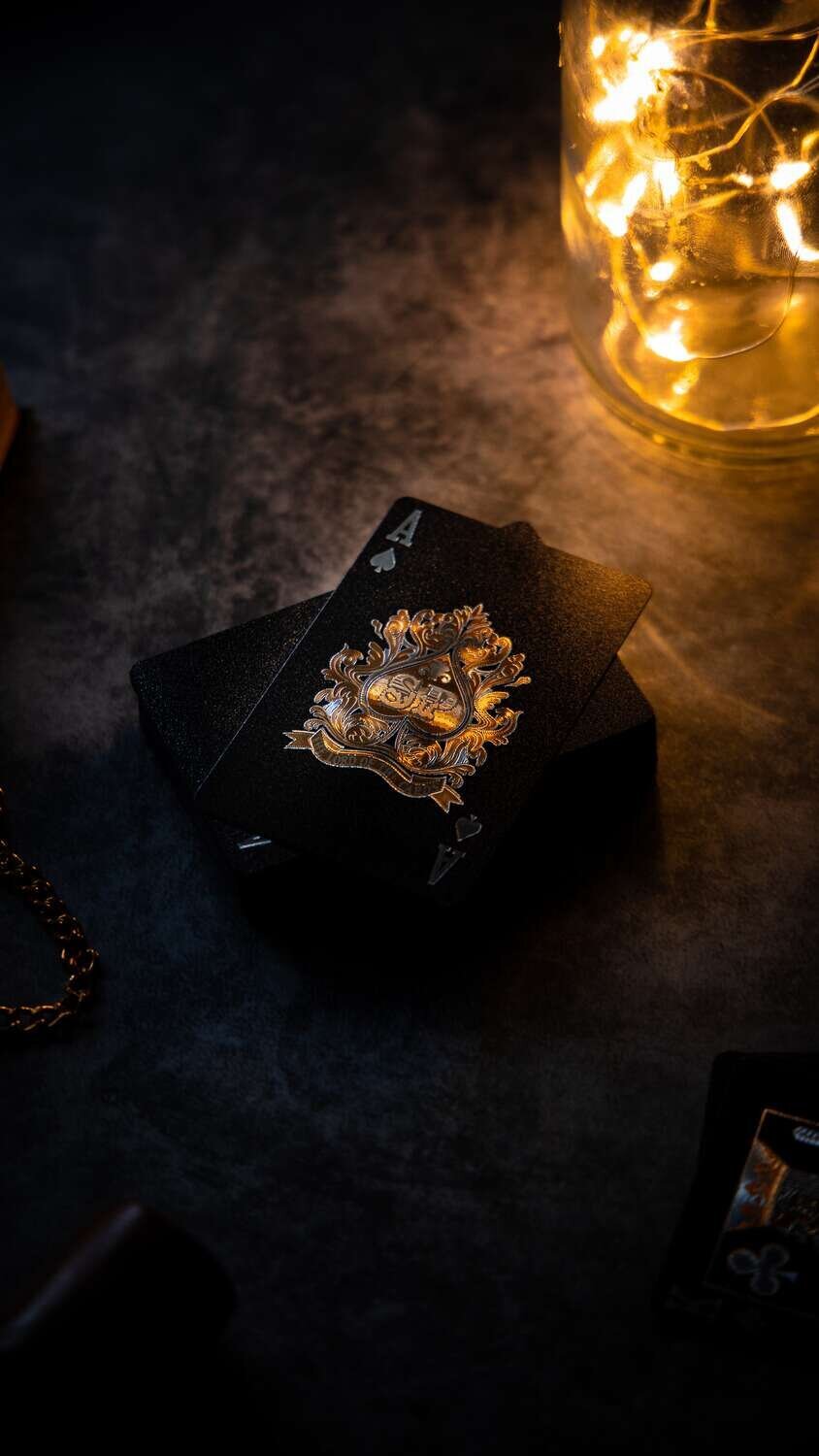 Black playing card deck with gold emblem