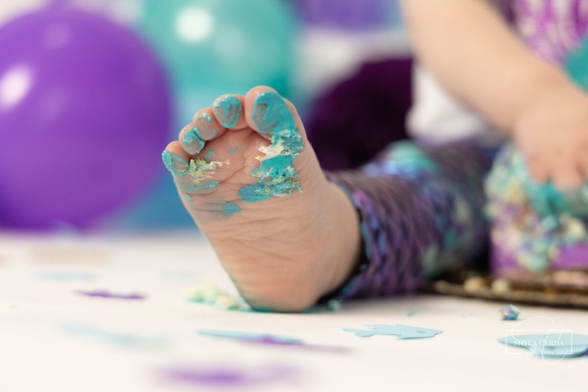 Baby foot covered in icing during studio cake smash