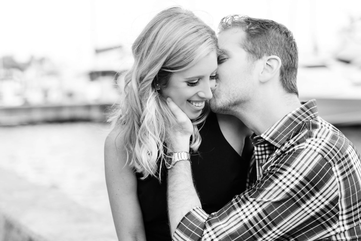 AA black and white image of a woman being kissed on the cheek while she laughs