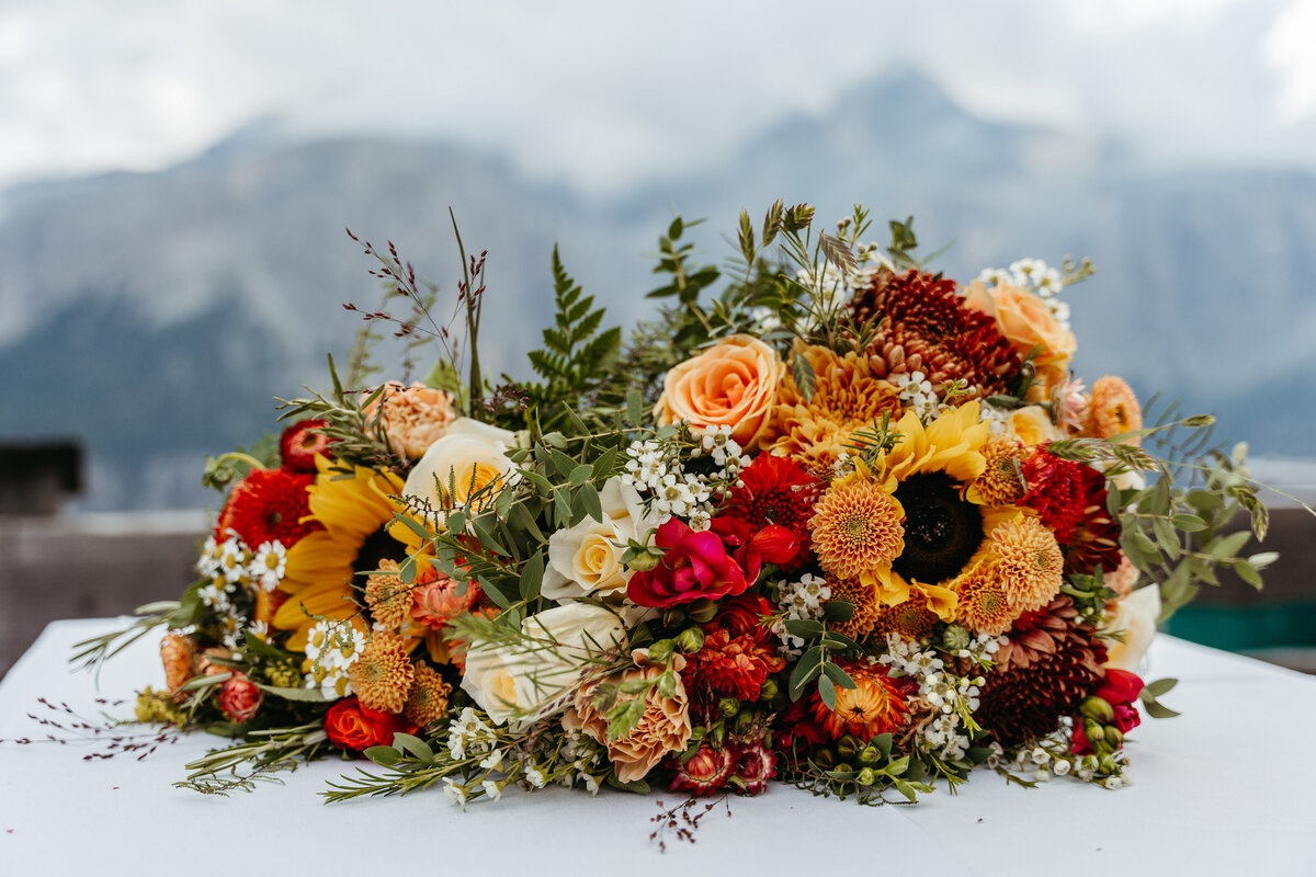 Sunflower and orange floral bouquet on rustic table