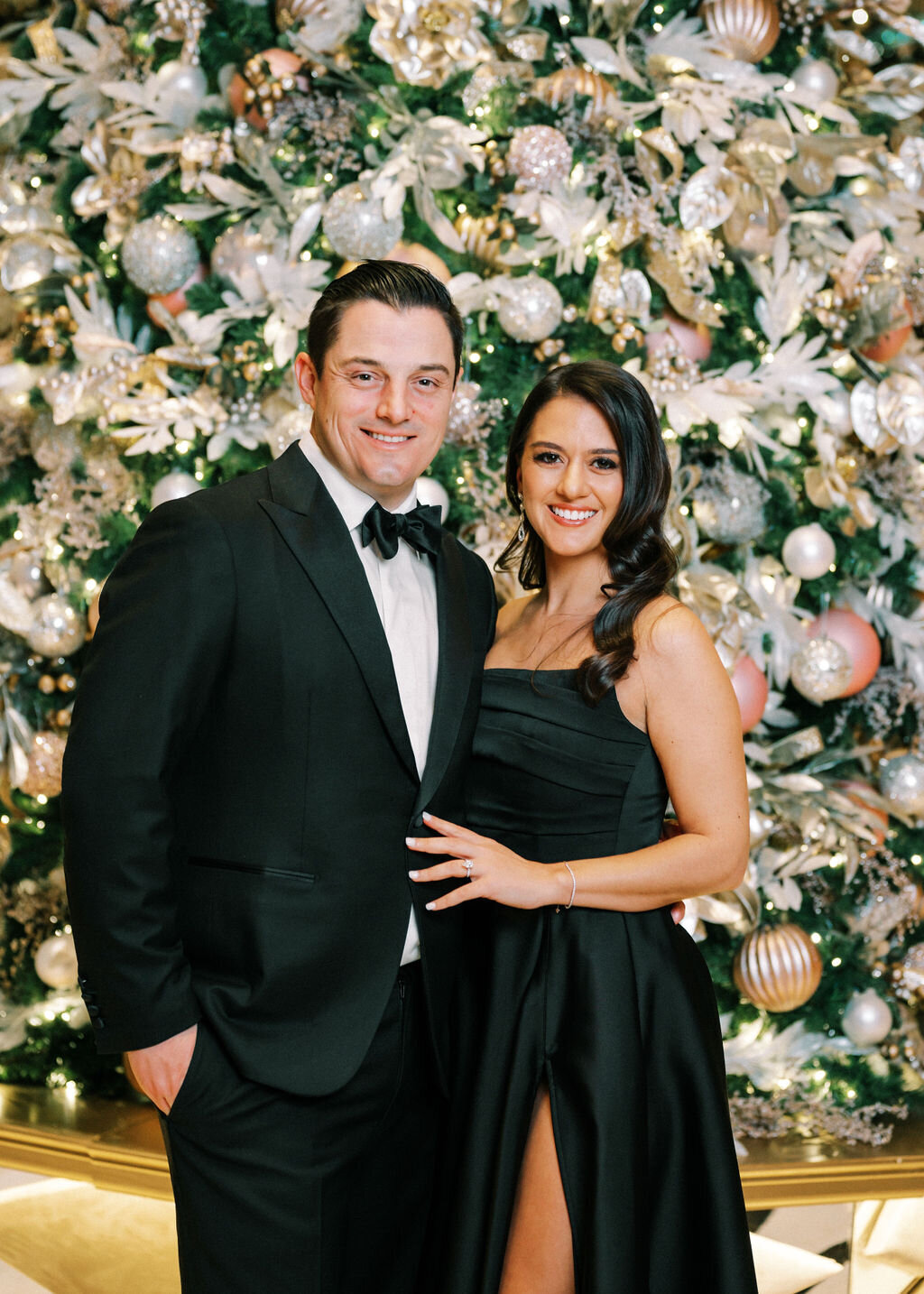 Close up photo of wedding guests in front of the Christmas Tree. 