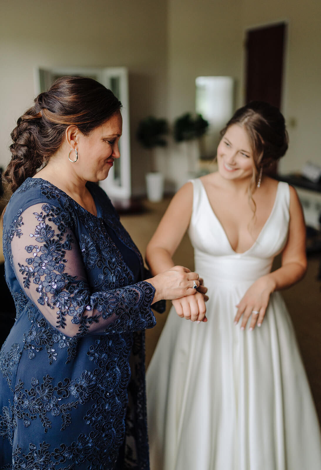 Mother putting bracelet on bride