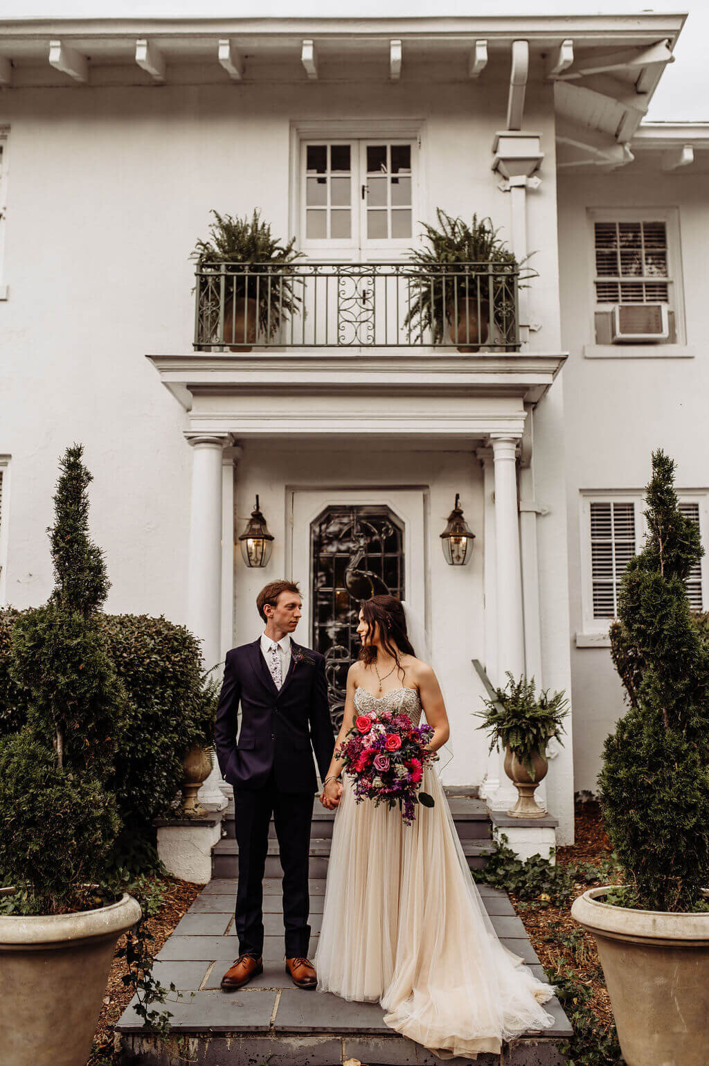Bride and Groom at the Finch House Wedding Venue under grand balcony