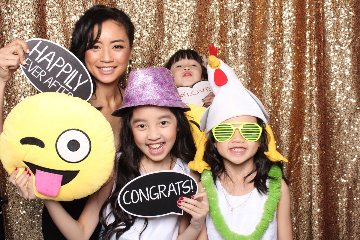 Mother poses with her three kids in a photo booth
