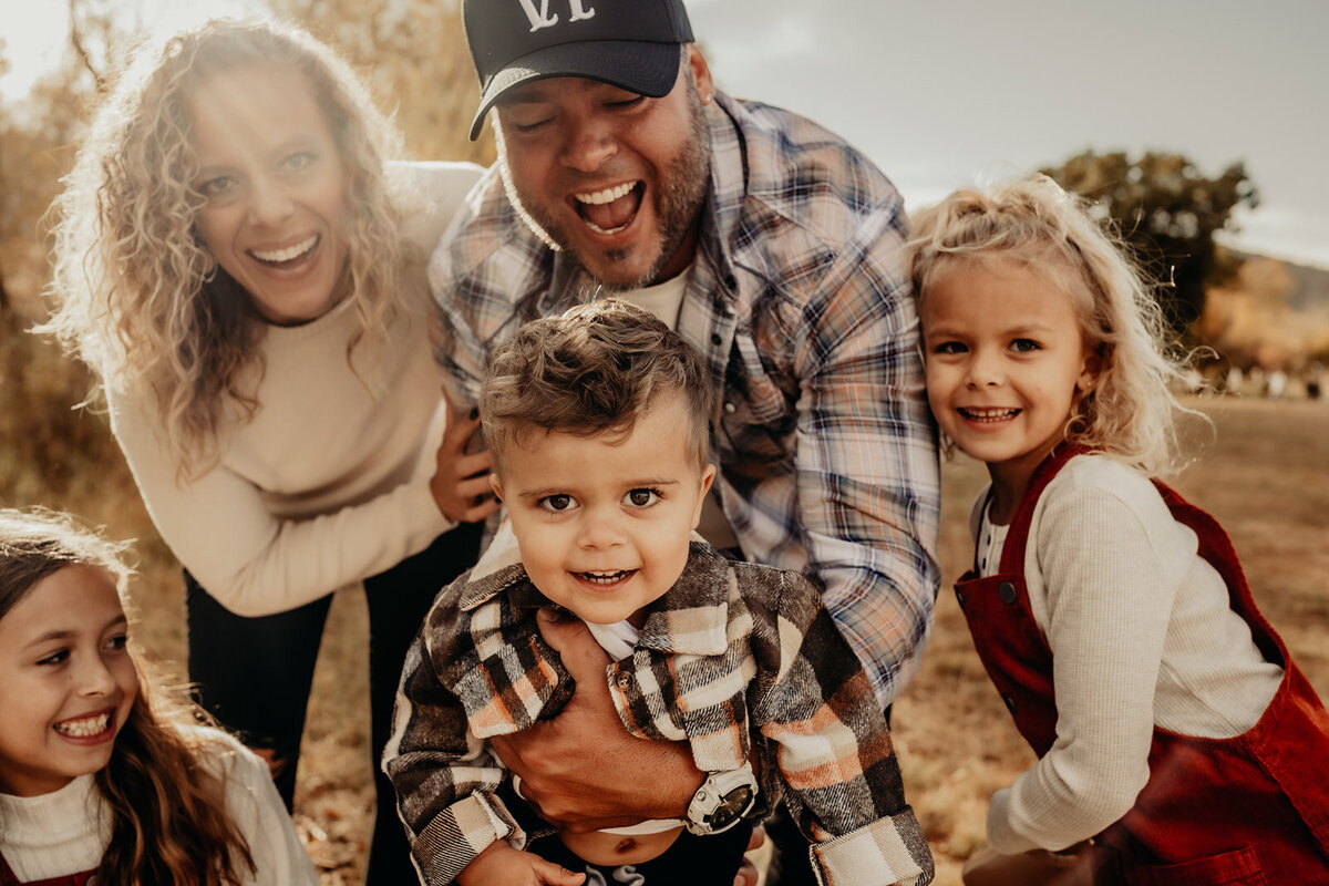 October fall family session in a beautiful landscaped park in Littleton, Colorado featuring an old barn