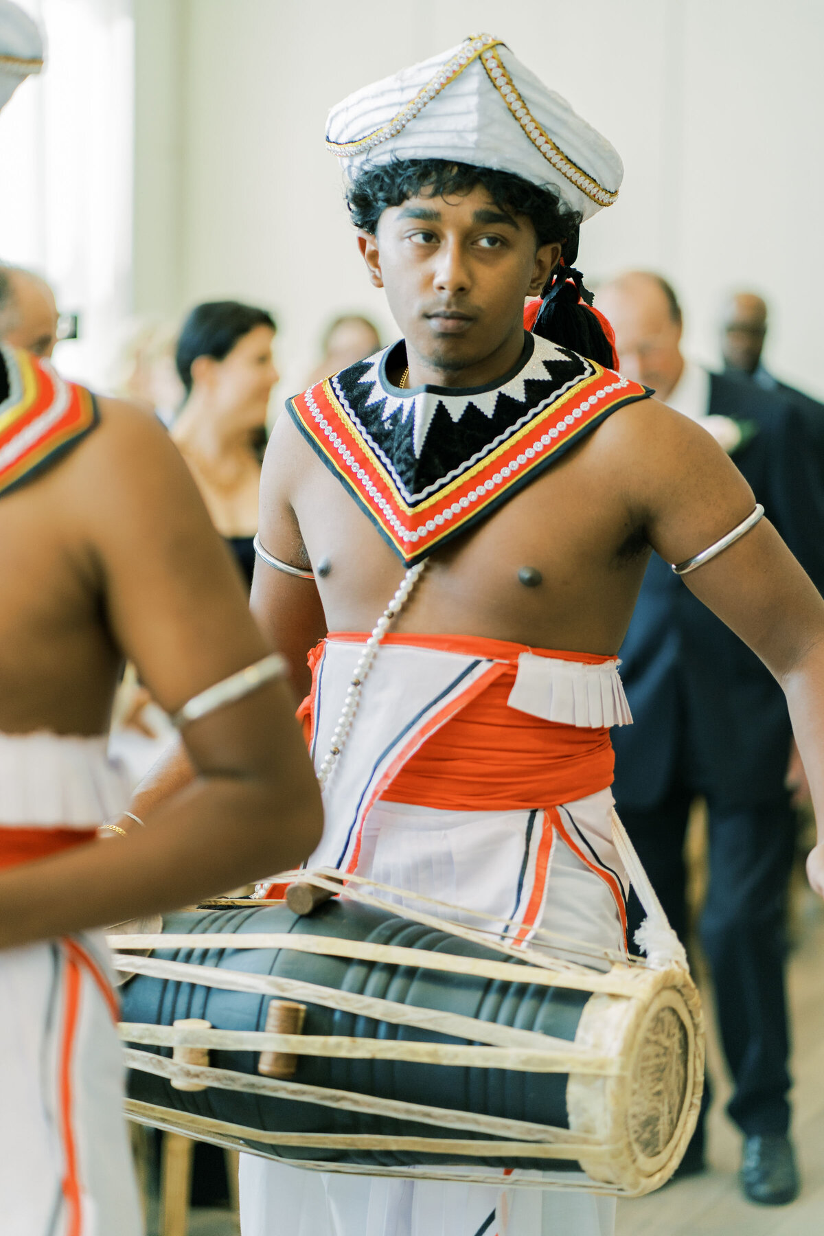 indian men are playing drums down the aisle at the pearle hotel