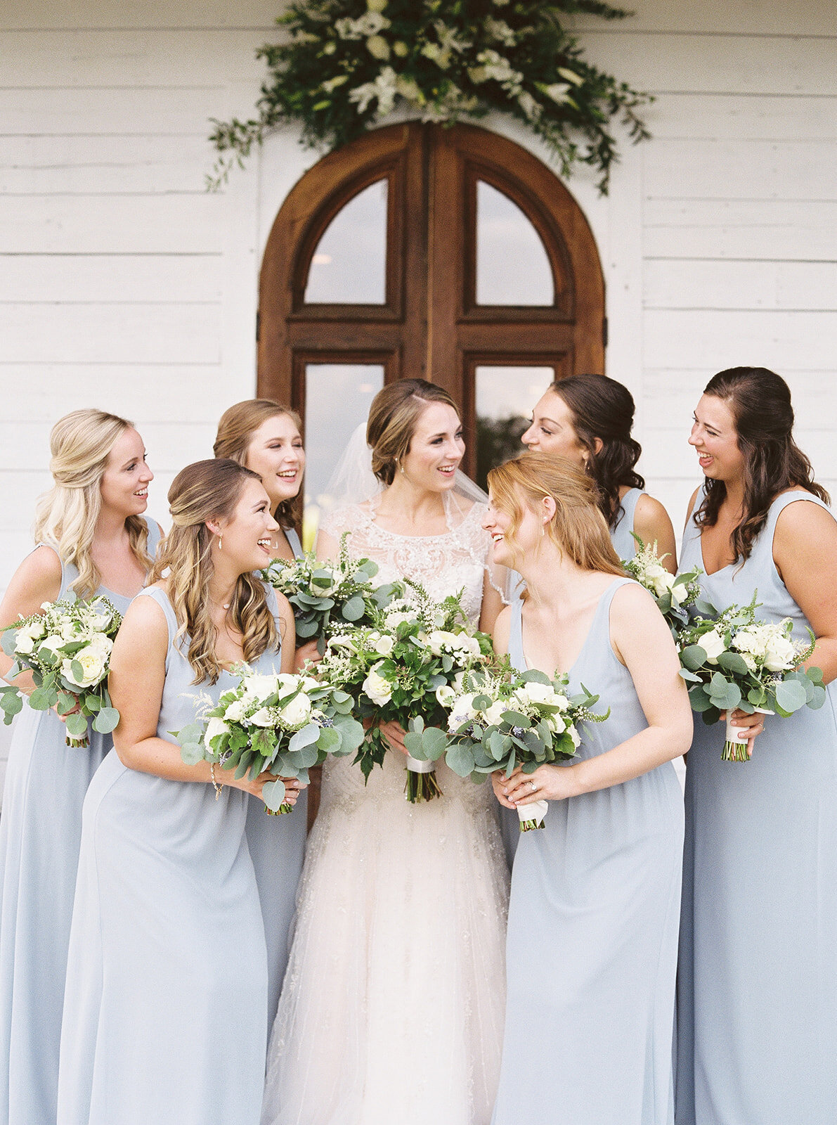 bride with bridesmaids in soft blue dresses