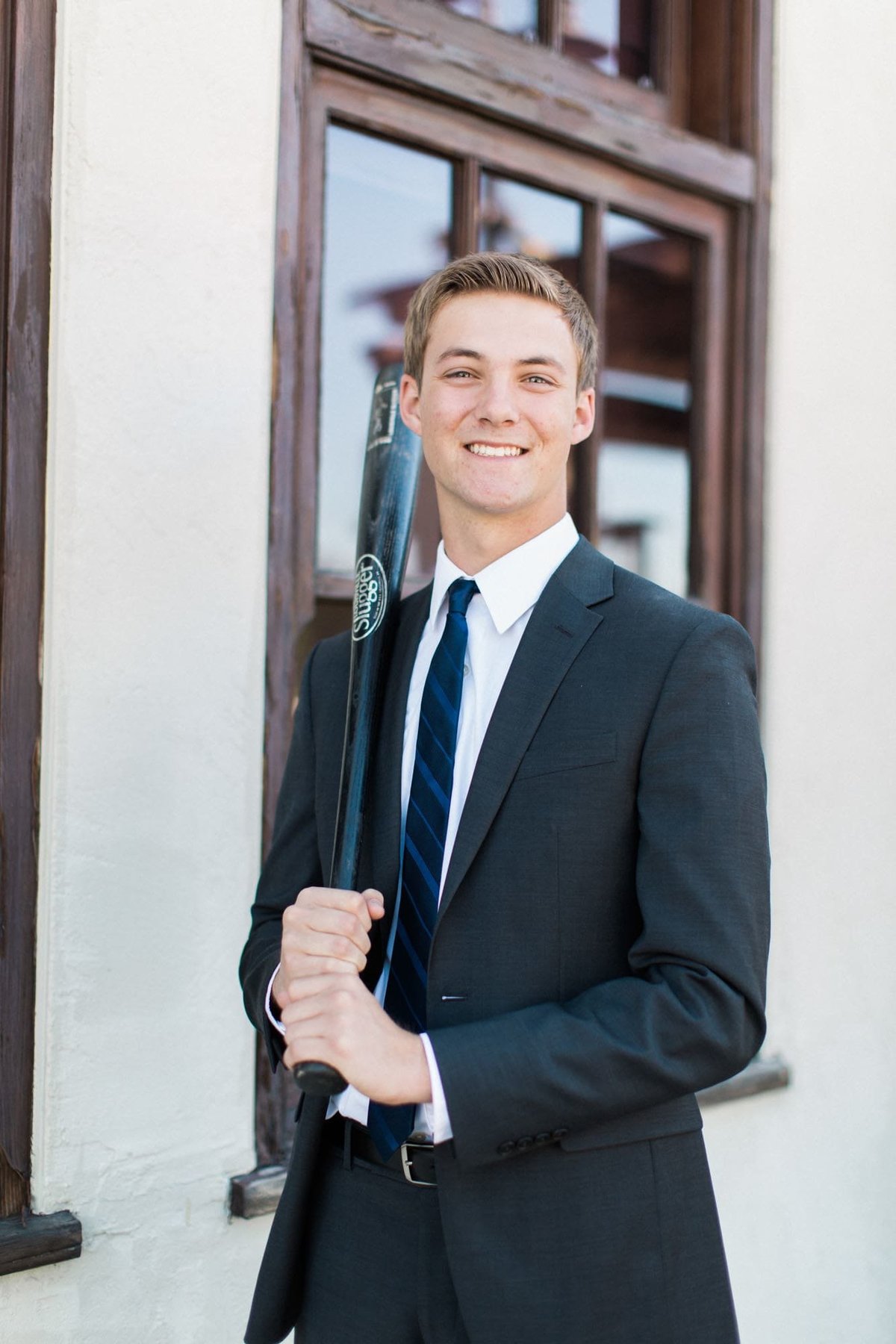 Young man posing with a baseball bat during his senior photos session