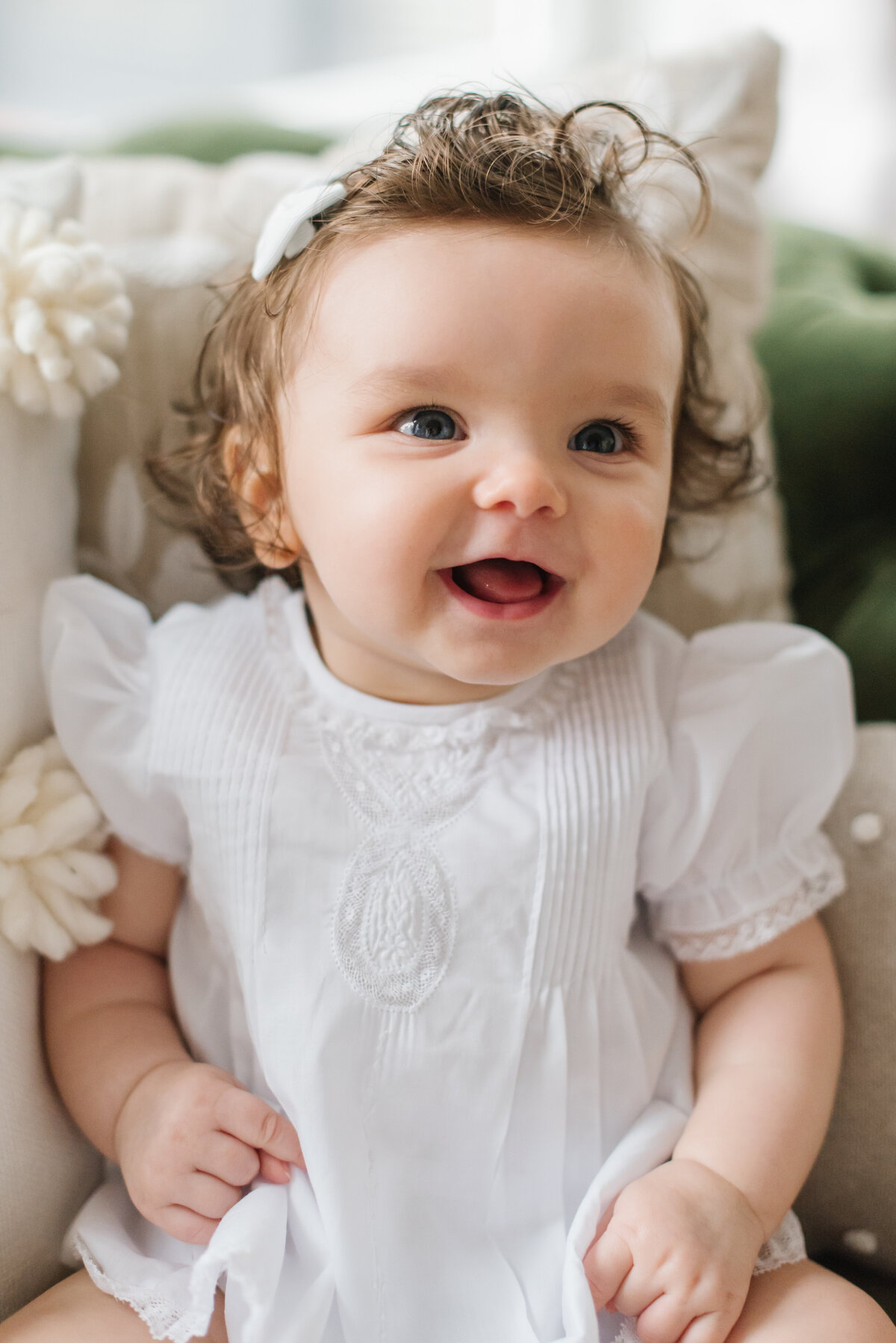Baby girl giggling in white dress