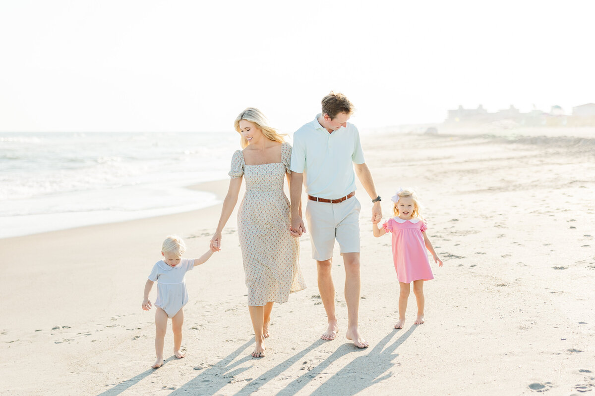 Family walking on Emerald Isle Beach holding hands