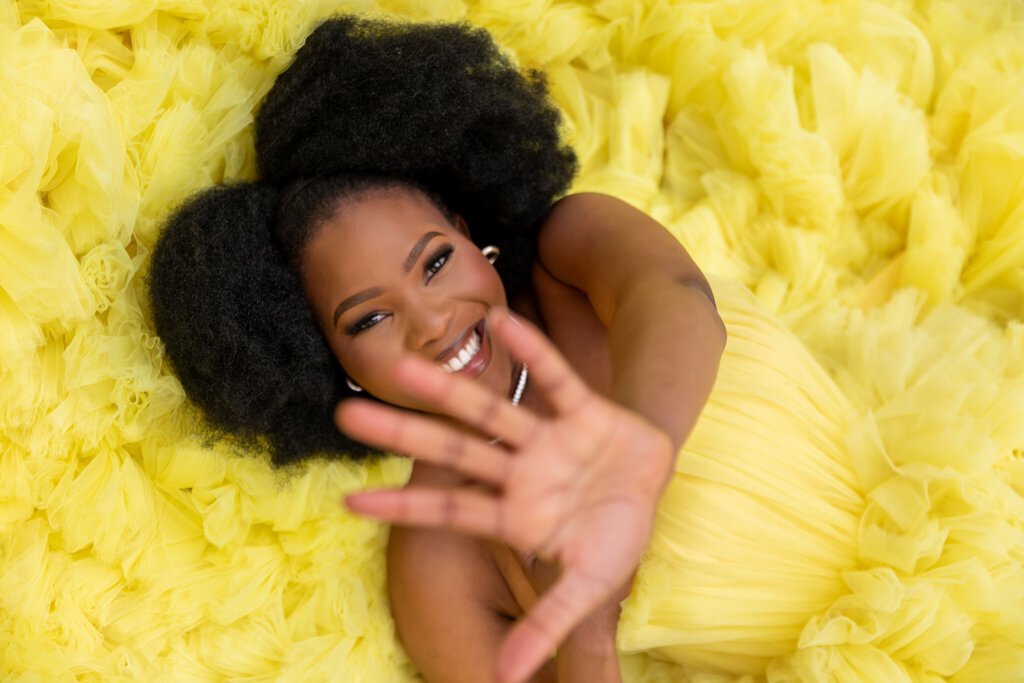 Creative portrait photography with woman laying on yellow fluffy dress